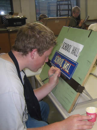 pupil painting a sign